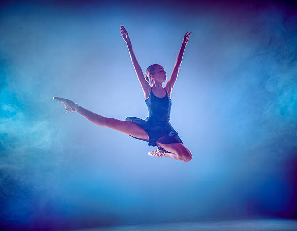 istock The silhouette of young ballet dancer jumping on a blue 500058800