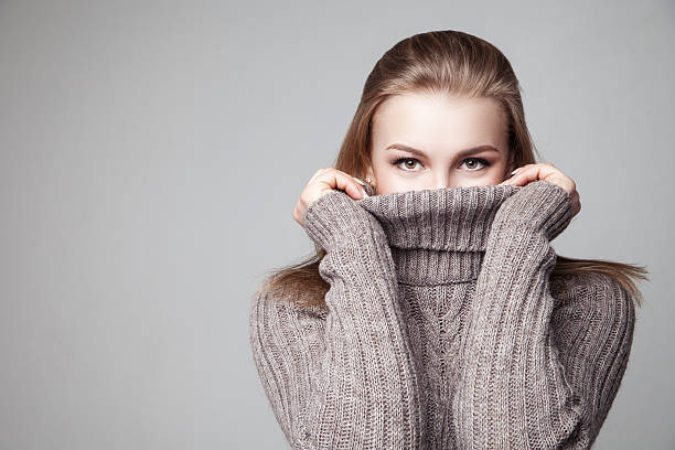 Beautiful blond young girl wears winter pullover Beautiful blond young girl wears winter pullover over gray background  turtleneck photos stock pictures, royalty-free photos & images