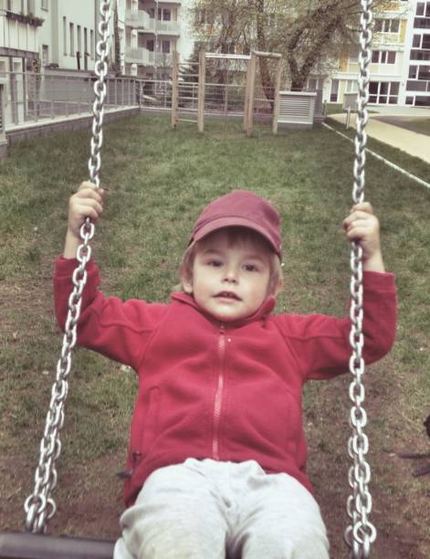 istock Portrait of boy swinging at playground 500064467