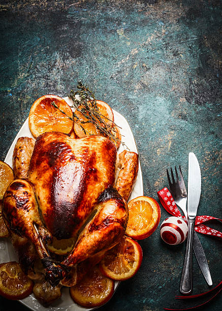 Roasted Christmas turkey with orange,  festive decoration Roasted Christmas turkey with orange slices served with  festive decoration on dark rustic background, top view sauces table turkey christmas stock pictures, royalty-free photos & images