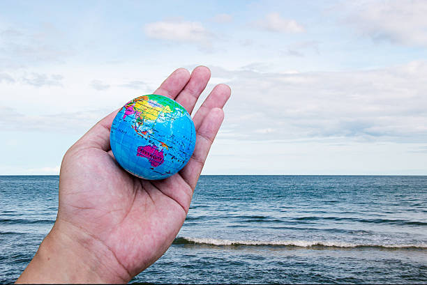istock hand hold worldlandscape ocean sky horizental line 500079850