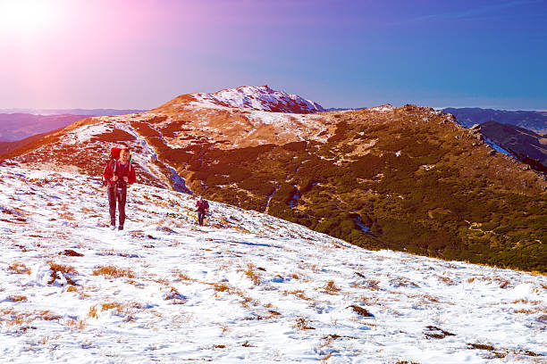 istock Two Hikers walking up Snow Slope Mountains View with Sun 500079942