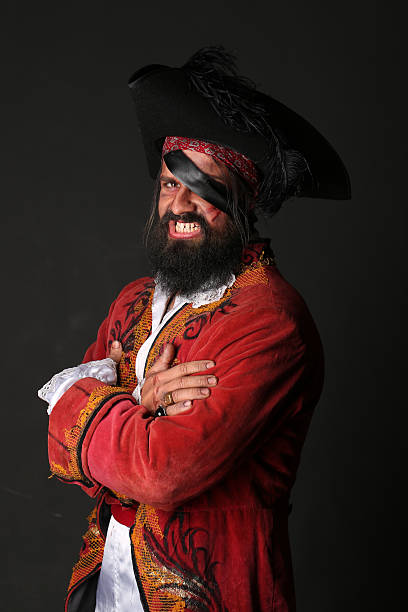 Portrait of handsome man in a pirate costume Portrait of handsome man in a pirate costume with hat and eye patch on black background bandana photos stock pictures, royalty-free photos & images