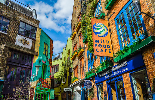 London, UK - March 27, 2015: Neal's Yard in Covent Garden. Photo taken during the day and features the colorful buildings and storefronts in the alley. There are no people represented in this photo.