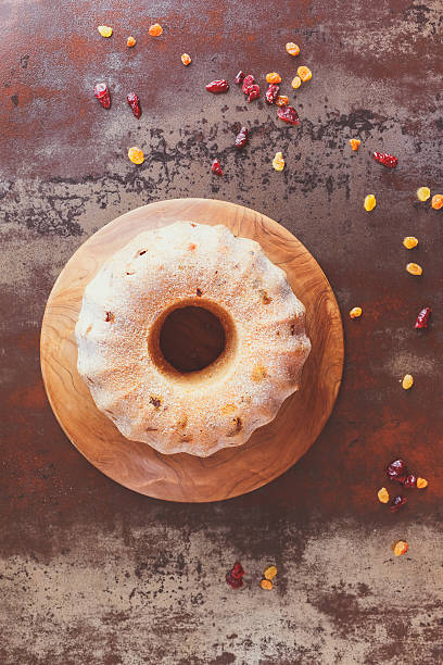 Fruit ring cake Fruit cake dusted with icing sugar on rustic background. Top view, blank space, vintage toned image carrot cake day stock pictures, royalty-free photos & images