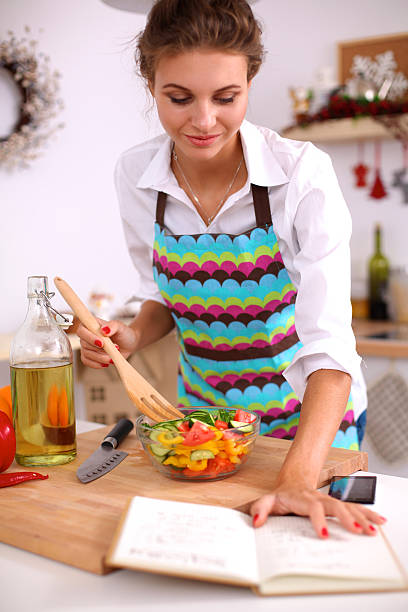 istock Smiling young woman  mixing fresh salad 500093602