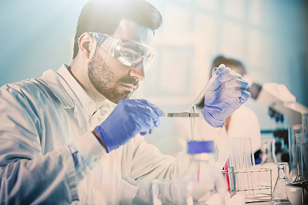 labor-techniker hält reagenzglas - scientist research test tube lab coat stock-fotos und bilder