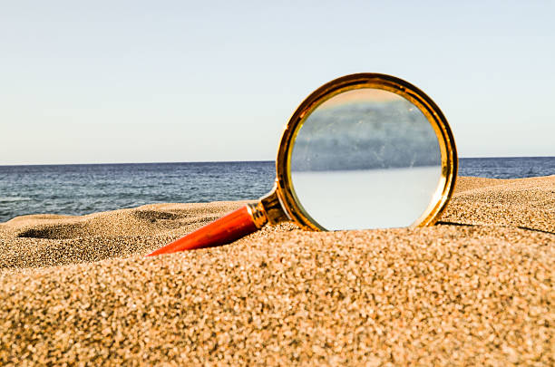 istock Magnify Glass on the Sand Beach 500110312