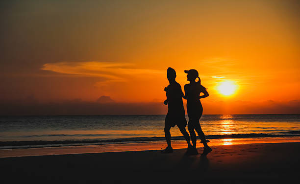 istock Young couple: man and woman run together on a sunset 500111880