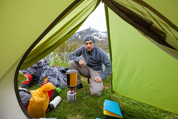 istock Hiker is looking into the tent while cooking near it 500113770