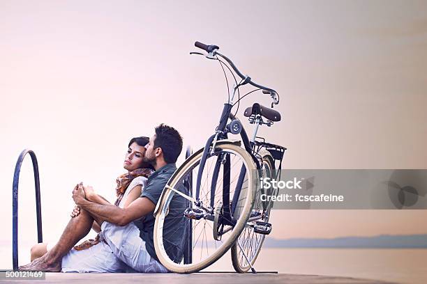 Couple In Love Resting On A Boardwalk At Lake Stock Photo - Download Image Now - Bicycle, Lake, Women