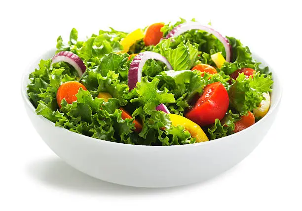 This is a photo of a white bowl of fresh salad. The background is a pure white allowing for endless copy.
