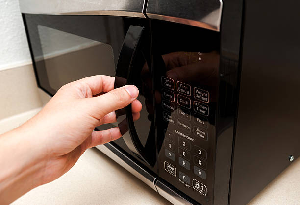 istock Hand openning microwave door close up 500122973