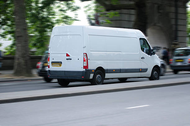 istock white moving van with blurred motion on the road 500124073