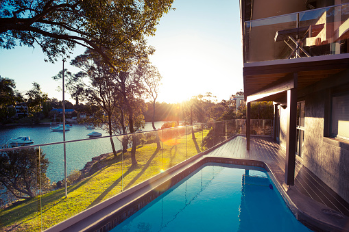 Waterfront house with swimming pool at sunset