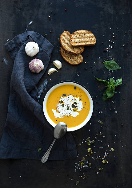 istock Pumpkin soup with cream, seeds, bread and fresh basil on 500132176
