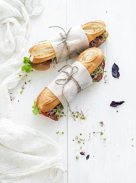 istock Sandwiches with beef, fresh vegetables and herbs over white wood 500132218