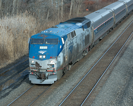 Amsterdam, New York, USA - December 5, 2015: Assorted antennas for PTC or positive train control, mandated for future use in the US. Shown installed on a Amtrak locomotive cab and designed to prevent missed signals, mis-aligned switches and speed limit infractions. Installation of the system is currently in progress. Note right windshield has a video camera mounted also. Snow plow mounted for snow states. Train is traveling upstate NY.