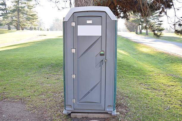 porta pot de vert et de gris, sous arbre sur le terrain de golf - porta potty photos et images de collection