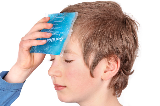 Person is cooling with an ice pack because of headache, school stress, insect sting, blain or others.