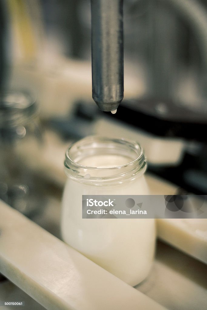 Conveyor with bottles filled with milk products, selective focus Factory Stock Photo