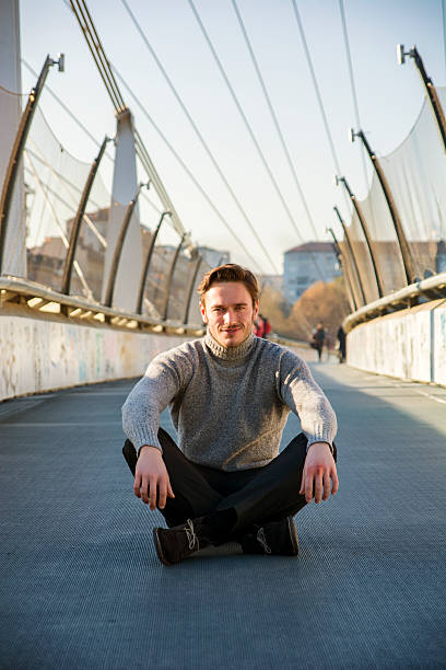 istock Handsome young man sitting outdoors in urban environment 500154954