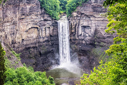 Tall waterfall at Taughannock Falls State Park near the village of Trumansburg - just northwest of the city of Ithaca - in New York State, USA. Water flows from the bottom of this gorge for less than a mile directly into Cayuga Lake - one of the largest of the New York State Finger Lakes. Looking down from this angle, it's difficult to appreciate the extreme height - 215 ft (65.5 m) - from which the water actually falls.
