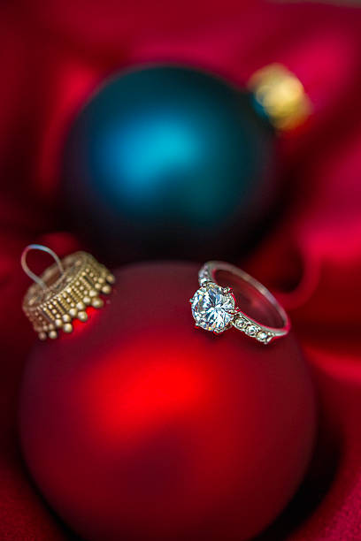 istock Christmas baubles with engagement ring in red satin 500159082