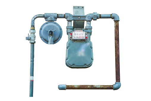 Weathered natural gas meter with rusty pipes isolated on white