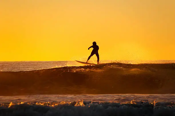 Young surfer standing on the wave