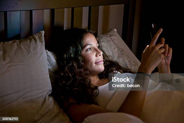 Teléfono En La Cama Foto de stock y más banco de imágenes de Cama - Cama, Noche, Mensaje de texto