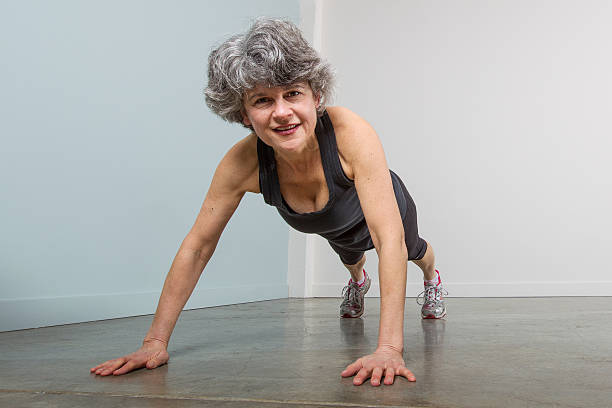 Middle Aged Female Sports Trainer in Pushup Position stock photo