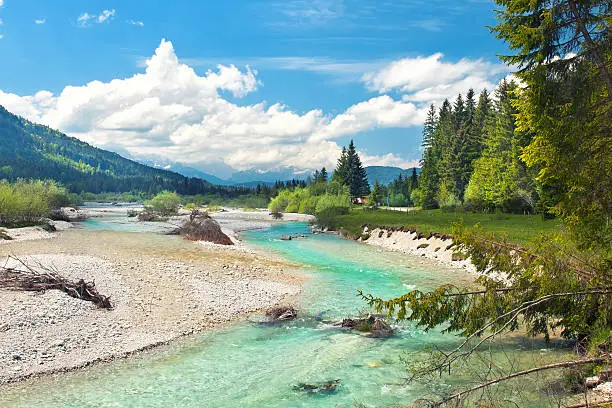turquoise wild river in alpine landscape on sunny summer day