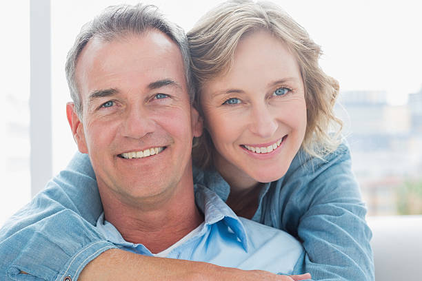 istock Smiling woman hugging her husband on the couch from behind 500175343