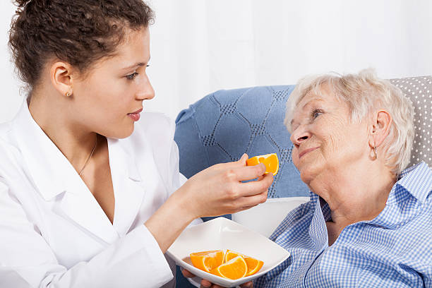 istock Nurse feeding an elderly woman 500176089