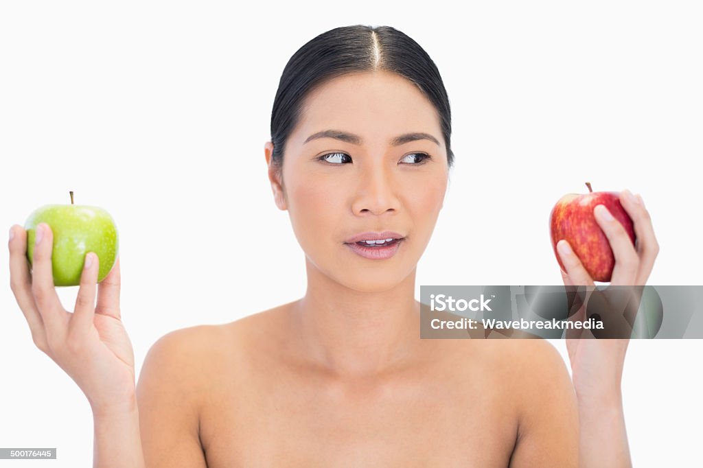 Curious black haired model holding apples in both hands Curious black haired model holding apples in both hands on white background 20-29 Years Stock Photo