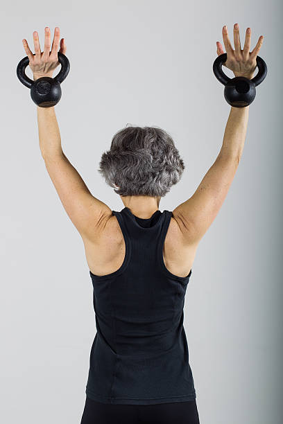 istock Middle Aged Female Sports Trainer With Kettle Bells 500176681