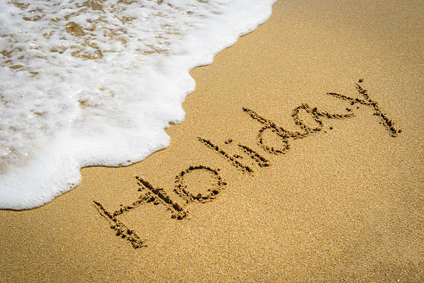 istock Word holiday on the beach sand 500176794