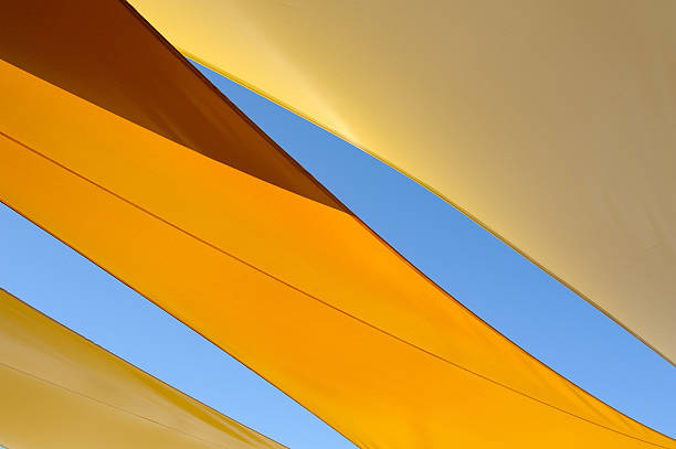 Yellow sunshade on a Thailand beach set against a clear blue sky.