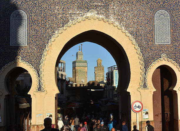 Morocco Gate Fes, Morocco - December 1st 2015: Moroccans pass through The Blue Gate in Fes (also called Bab Boujeloud), the historic landmark entrance to the Medina (old city)  bab boujeloud stock pictures, royalty-free photos & images