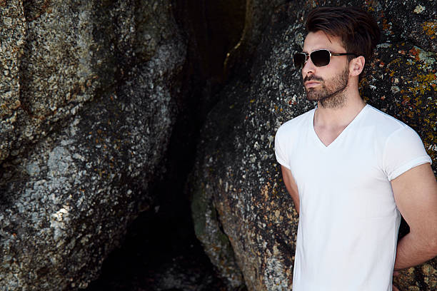 istock Man in shades against rock 500186048