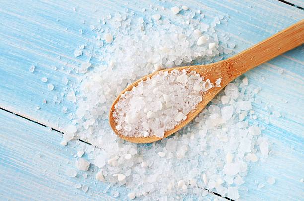 Sea salt on wooden table wooden spoon large grains of sea salt on shabby light blue table spoon photos stock pictures, royalty-free photos & images