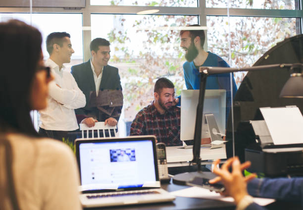 istock Young colleagues using laptop in the office among blurred people. 500189830