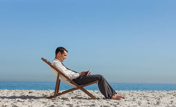 istock Young businessman resting on his deck chair using his tablet 500193895