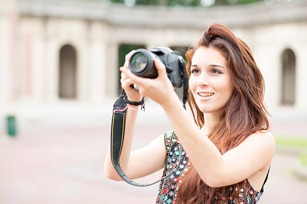 istock Smiling woman holding camera and taking pictures. 500195823