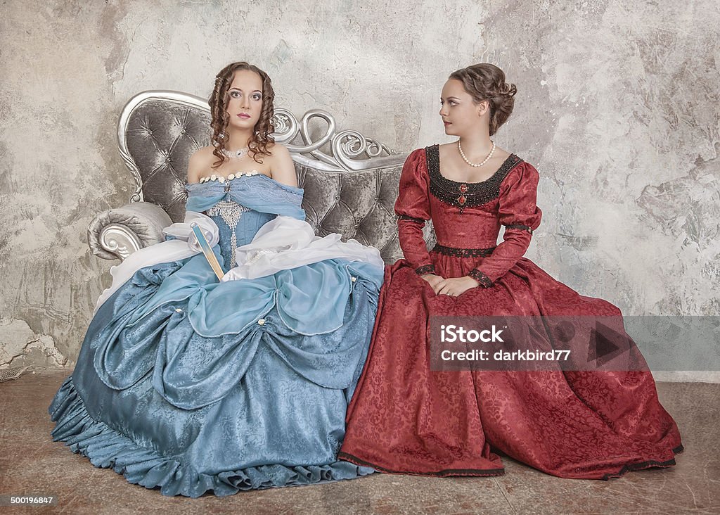 Dos Hermosas Mujeres En Medieval Vestidos En El Sofá Foto de stock y más  banco de imágenes de Estilo victoriano - iStock