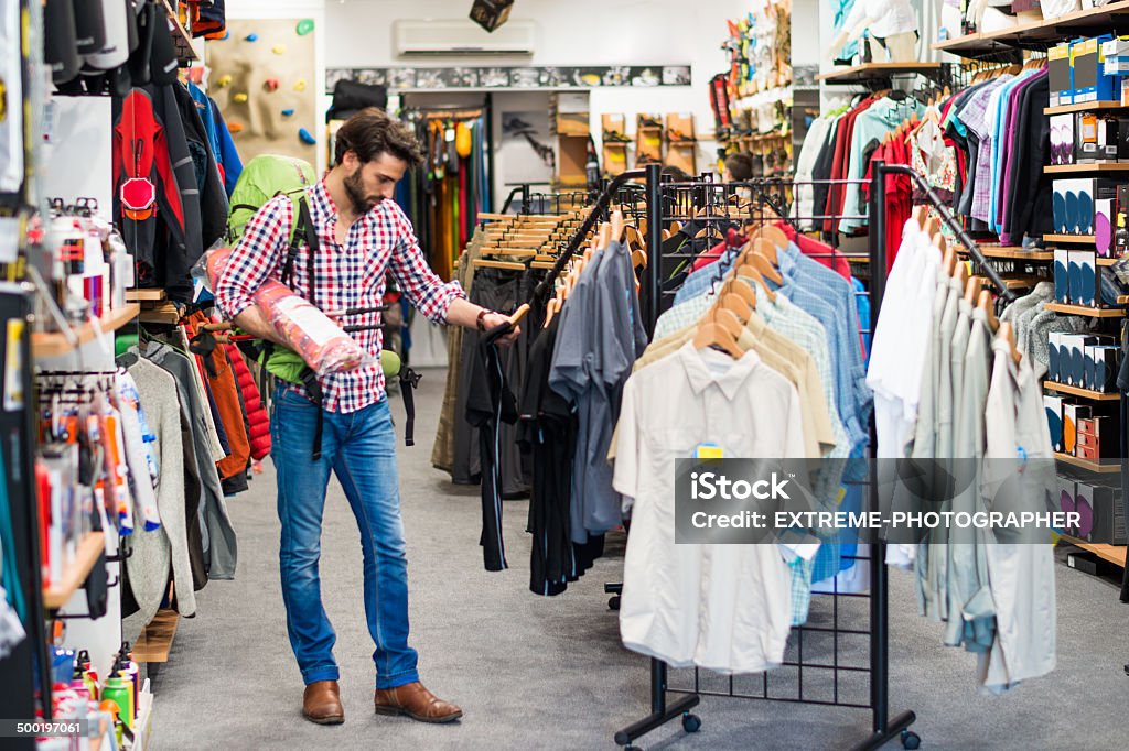 Man in the sports store Man in sports & outdoor store buying items for outdoor activities. Selling Stock Photo