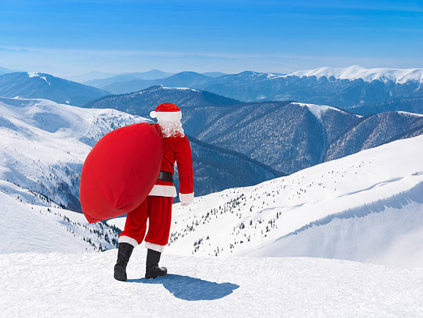 santa claus mit weihnachten tasche vor schnee winter berg landschaft - ski resort hut snow winter stock-fotos und bilder