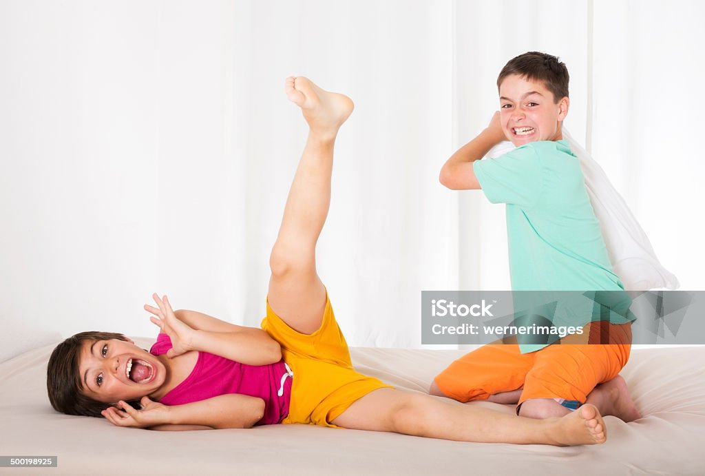 pillow fight two boys having a pillow fight and laughing Activity Stock Photo