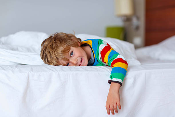 istock Adorable kid boy after sleeping in his white bed 500199478